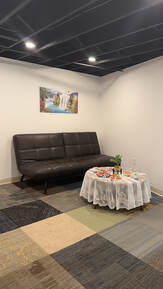 Picture of waiting area at Peaceful Massage (616) 308-1957 Black couch and coffee table